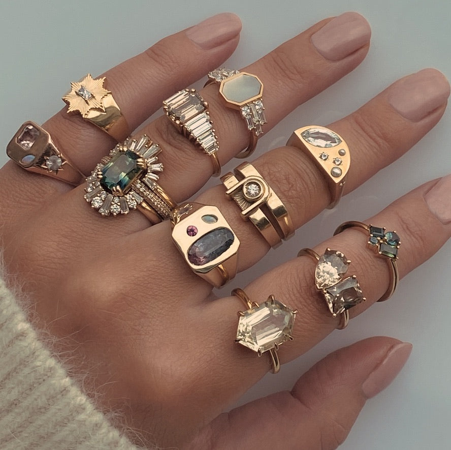 A hand wearing several White November rings together