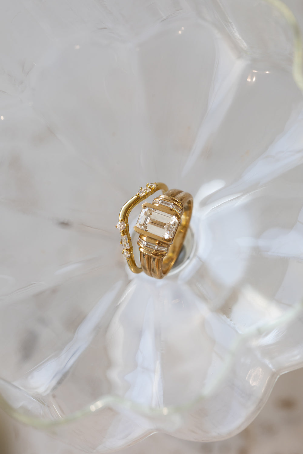 A hand holding a wide gold band, engraved on the inside.