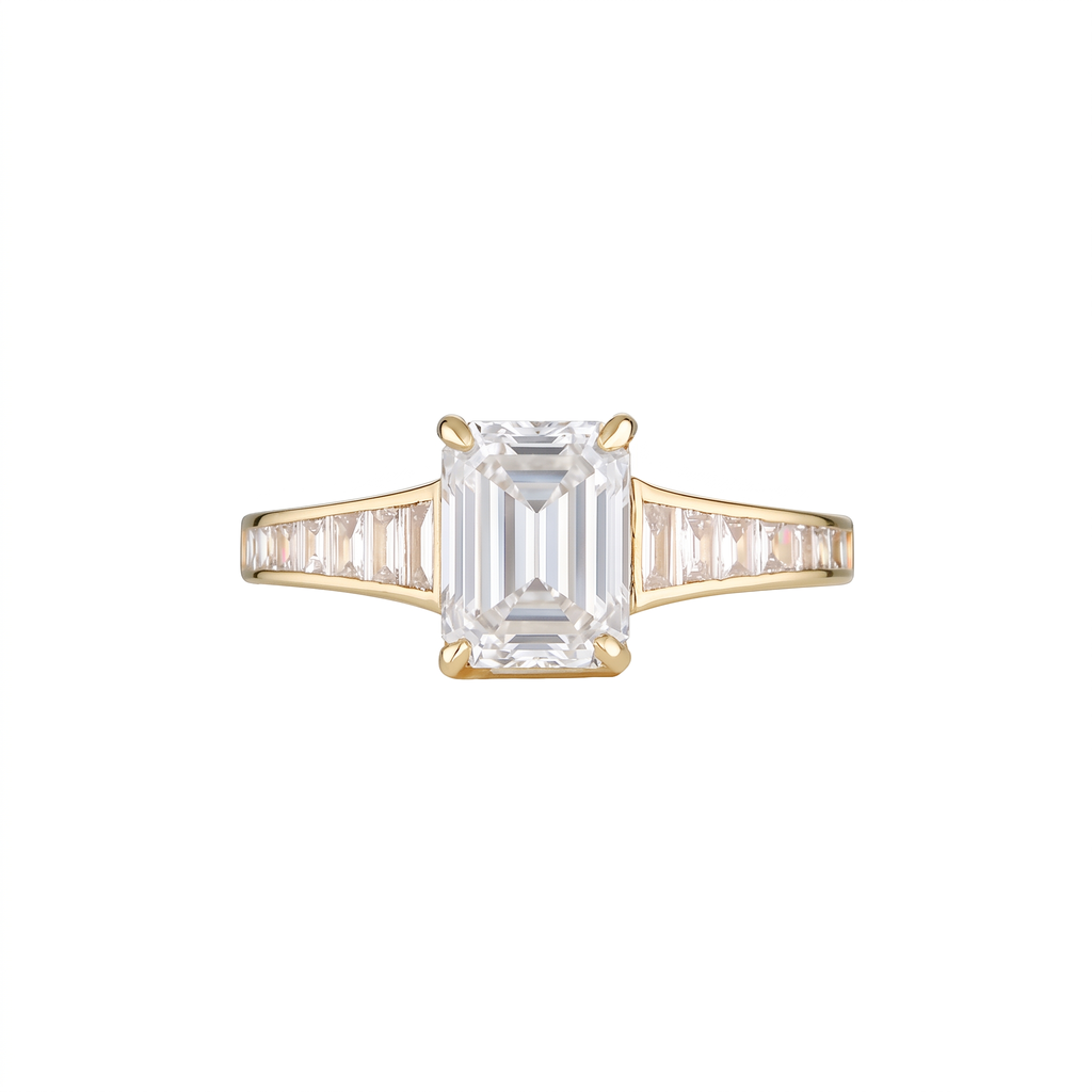 Empire Ring with white emerald cut diamond centre stone in 18k yellow gold with channel-set white baguette diamond shoulders