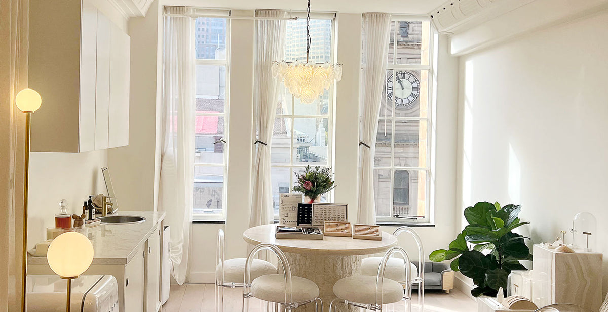 The White November studio on Collins Street: a round table under a chandelier, tall windows onto the city.